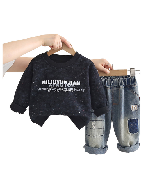 Black sweater with text and denim shorts on a hanger against a white background